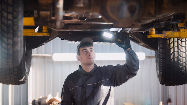 mechanic-with-thr-lamp-is-checking-bottom-car-garage-automobile-service_274719-248.avif